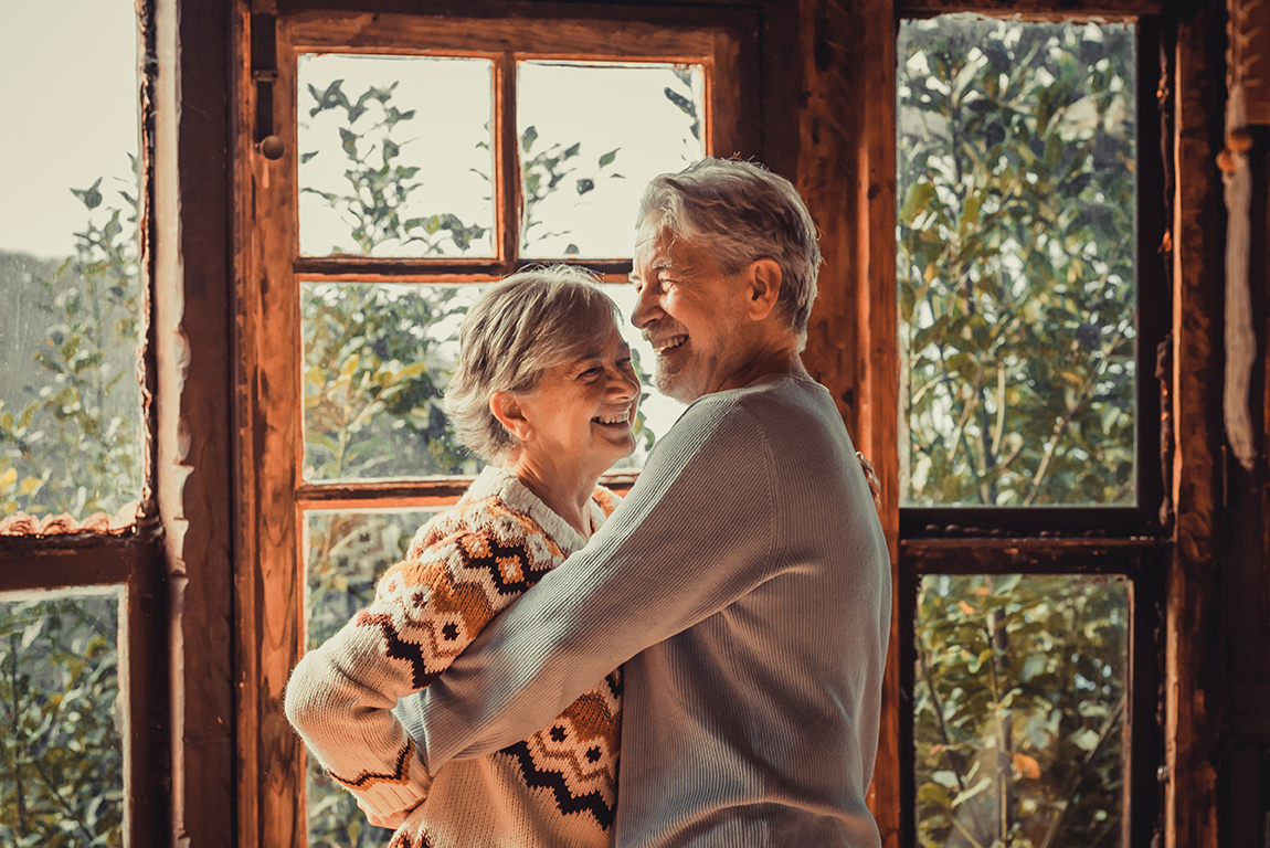 retired couple embracing in kitchen